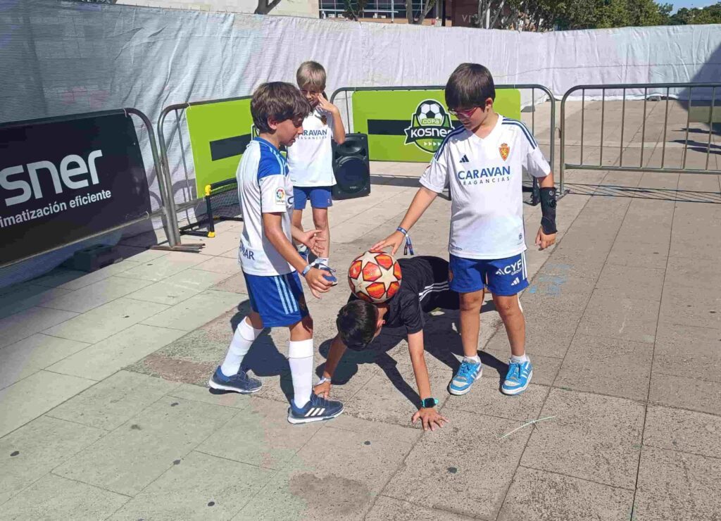 Participantes disfrutando de un taller de fútbol freestyle en evento deportivo.