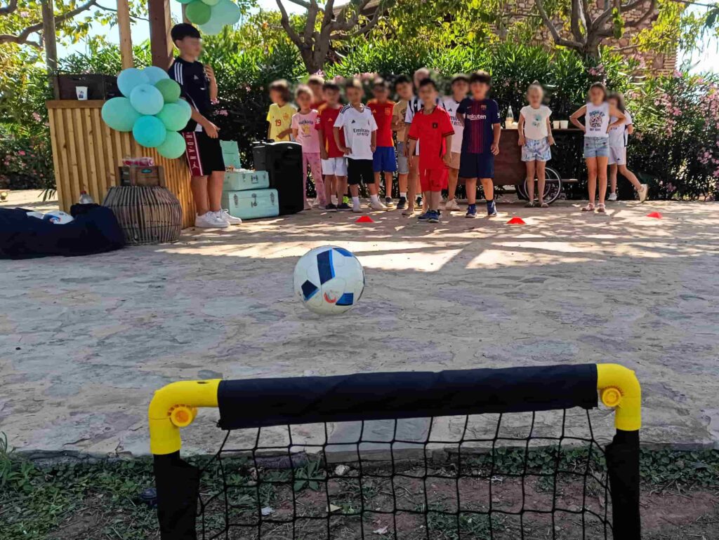 Niños participando en show de fútbol freestyle durante animación de cumpleaños en jardín