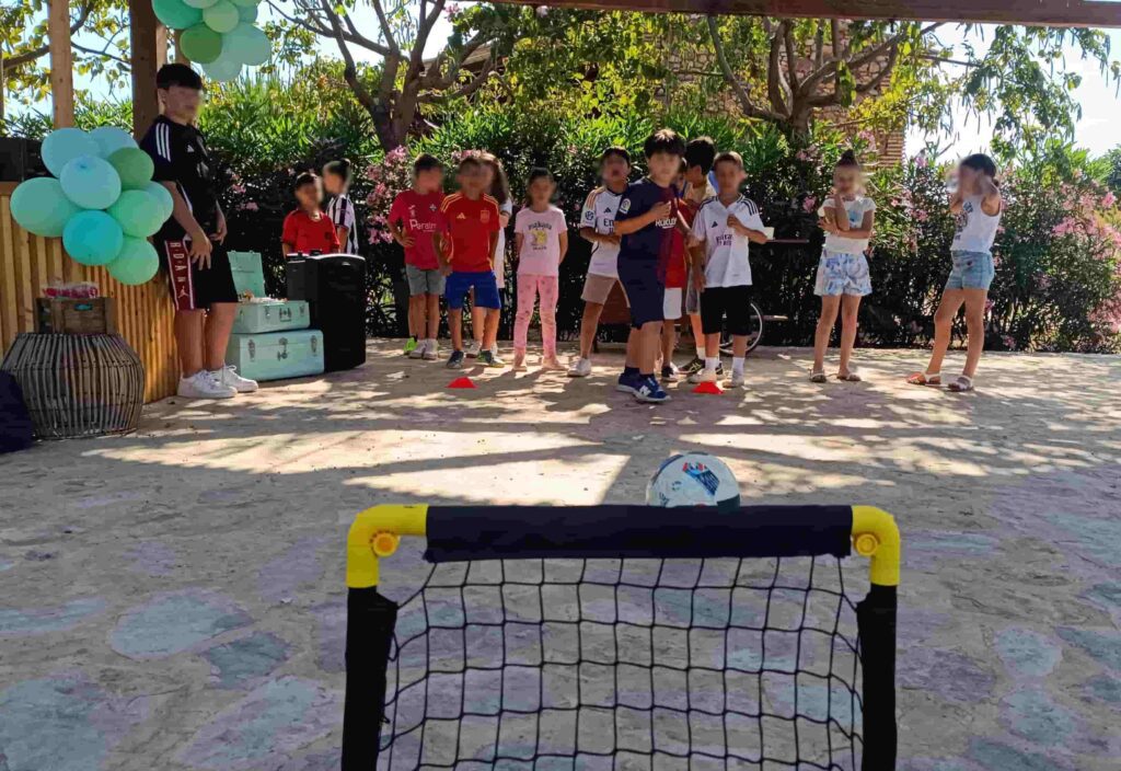 Niños participando en un divertido reto de puntería en un cumpleaños de fútbol infantil